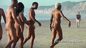 זוג רב גזעי עם חזה גדול נהנה מגילוי עירום על החוף
