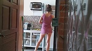Femme de chambre travestie en robe transparente nettoie la maison