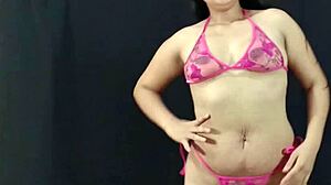 Kecantikan Latina muda dan berlekuk memamerkan asetnya dalam lingerie pink dan bersiap-siap untuk sesi foto yang panas