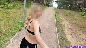Блондинка тренируется на улице в парке, обнажая свое голое тело и подпрыгивающие груди